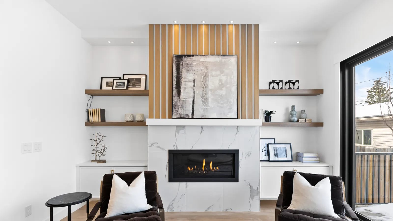 Naturally lit luxury Calgary living room with a marble fireplace feature wall and designer furnishings, an example of listing photography that sells