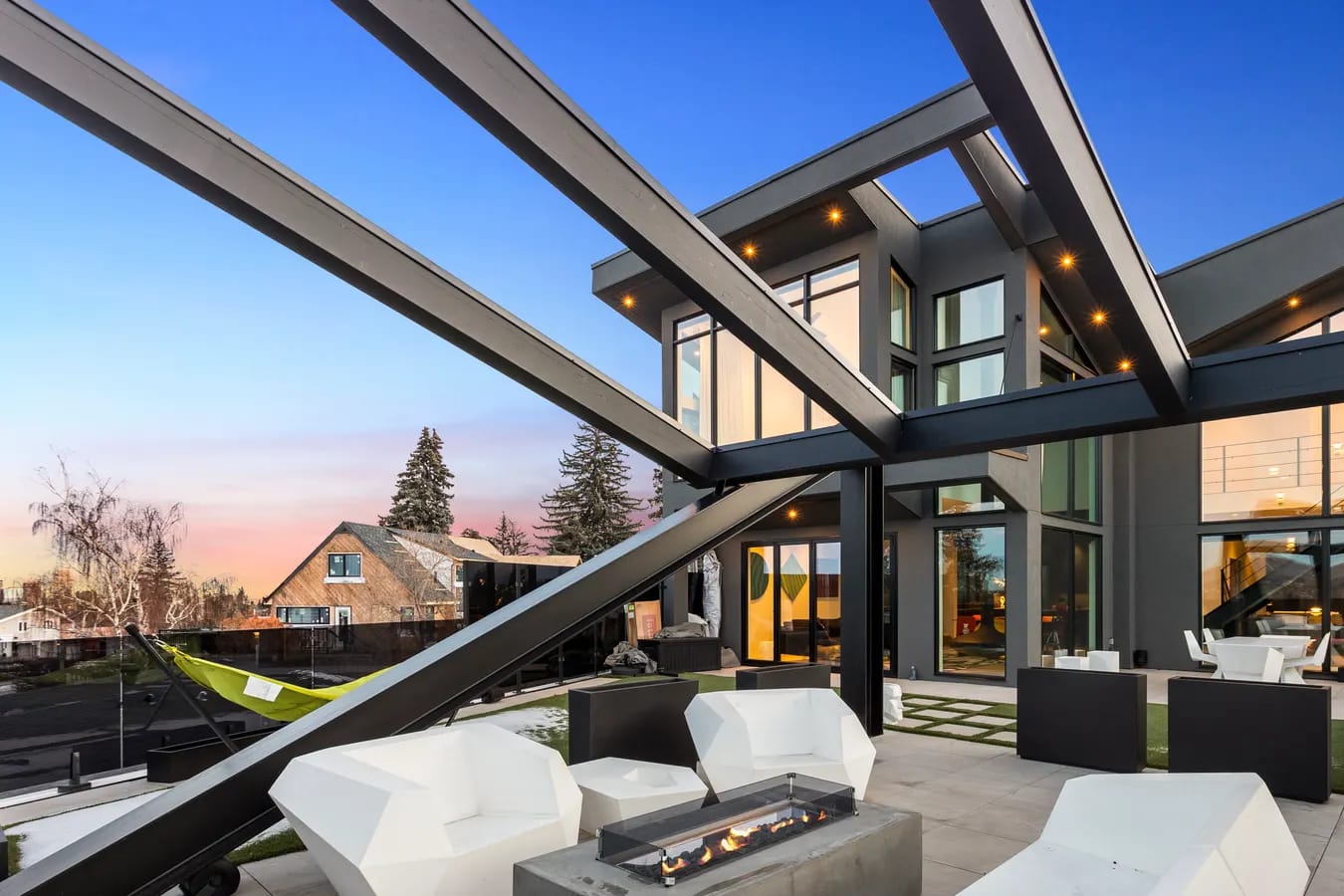 Twilight rooftop patio of a luxury Calgary home with a glass railing and fire feature, the kind of scroll-stopping listing content repurposed across a month of social posts