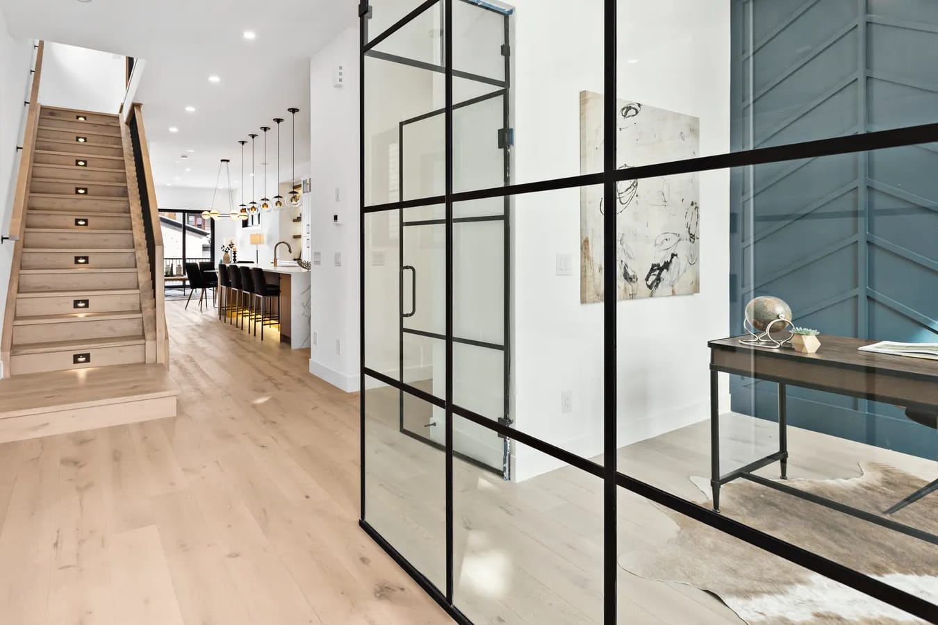 Architectural interior of a Calgary home with a staircase and glass-walled entry, representing precise spatial measurement to Alberta's RMS standard