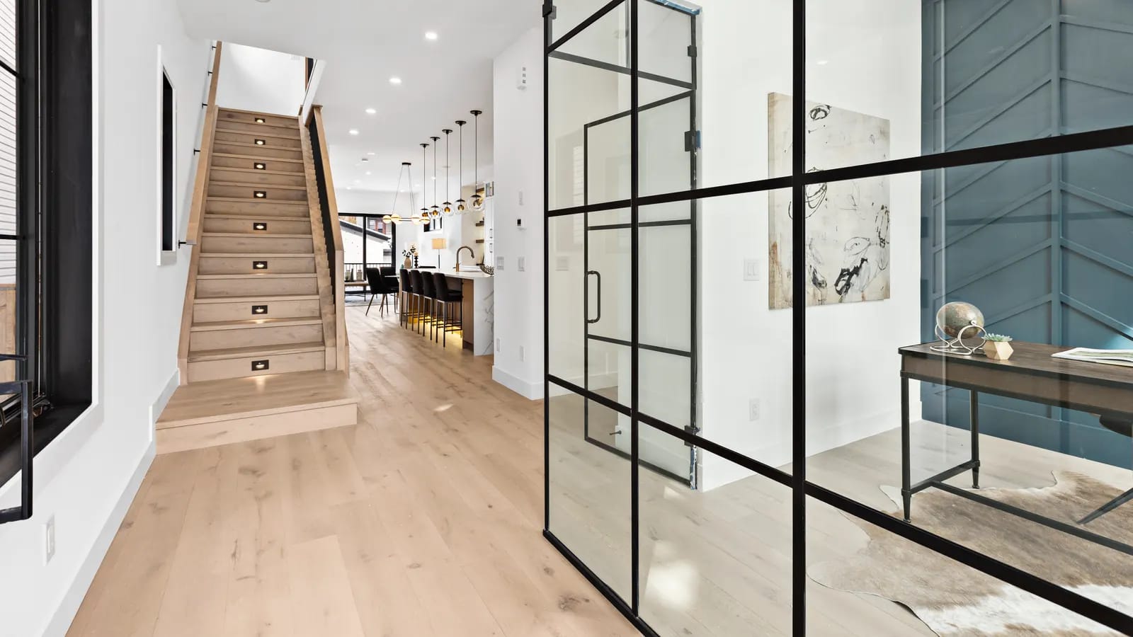 Architectural interior of a Calgary home with a staircase and glass-walled entry, representing precise spatial measurement to Alberta's RMS standard